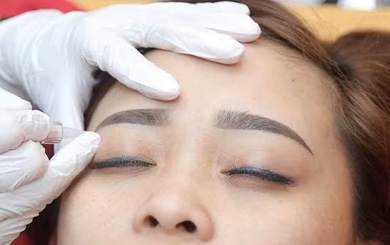Xăm lông mày tại tiệm chăm sóc sắc đẹp. Hình minh họa