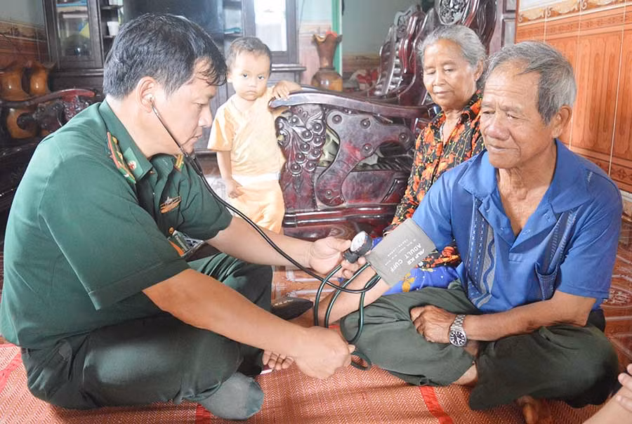  Thiếu tá Trần Văn Dũng đang chăm sóc sức khỏe cho ông Siu Thiu. Ảnh: A.H