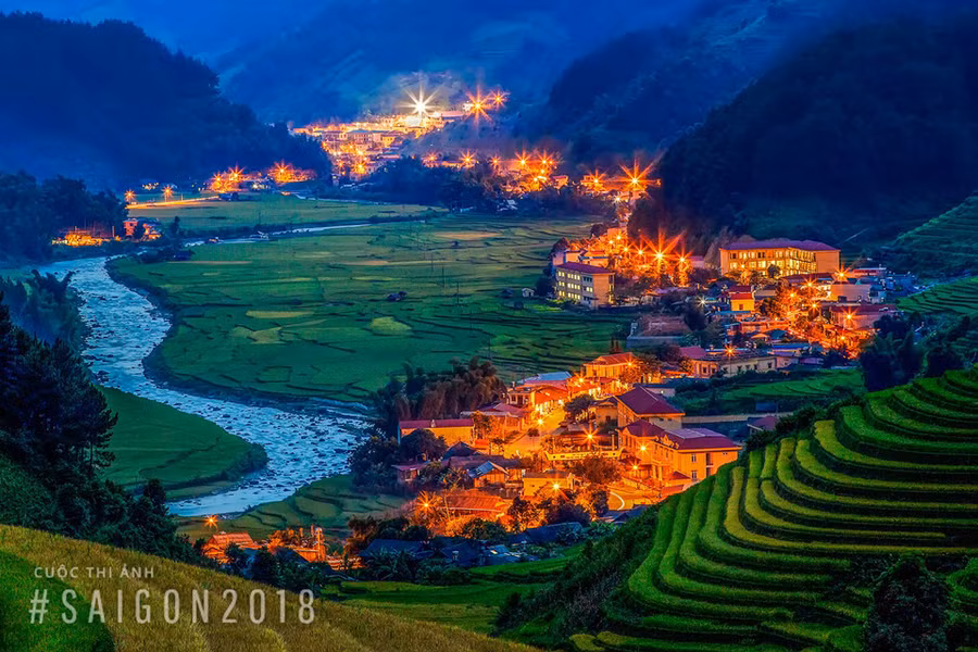 “Phố núi Mù Cang Chải lên đèn” của tác giả Nguyễn Nhật Cường. Để chụp được bức ảnh này, tác giả Cường chia sẻ anh và những người bạn đã phải leo bộ một quãng đường chừng 5 km lên núi trong điều kiện trời chập choạng tối.