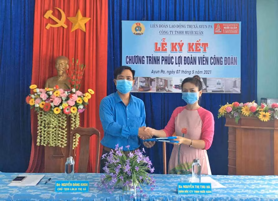 Lãnh đạo LĐLĐ thị xã Ayun Pa và Công ty TNHH Mười Xuân (bìa phải) ký kết thỏa thuận hợp tác chương trình phúc lợi cho đoàn viên và người lao động trên địa bàn thị xã. Ảnh: Nguyên Hương