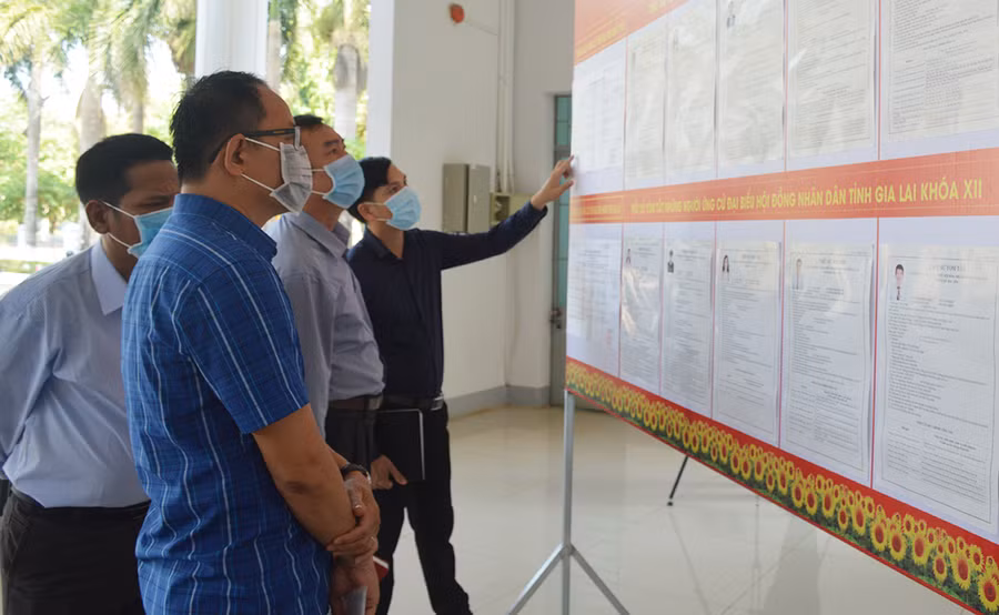 trước khi tham gia hội nghị, các cử tri huyện Chư Prông tranh thủ đọc tiểu sử, lý lịch trích ngang của các ứng cử viên.jpg
