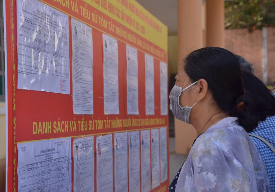 10-5 Cử tri phường Tây Sơn theo dõi thông tin của các ứng cử viên được niêm yết trước UBND phường Tây Sơn trước khi vào Hội nghị tiếp xúc cử tri-ảnh Phương Linh