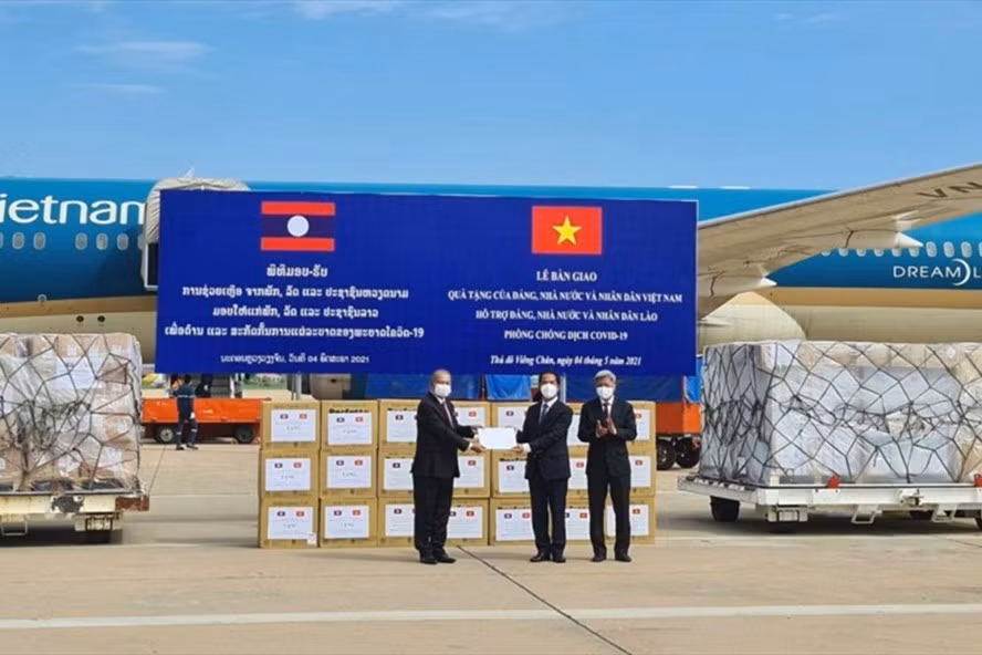  Thứ trưởng Ngoại giao Tô Anh Dũng trao tượng trưng quà tặng của Việt Nam giúp Lào ứng phó dịch COVID-19 cho Phó Thủ tướng Kikeo Khaykhamphithoun. Ảnh: BNG