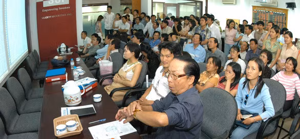Nhà đầu tư hồi hộp theo dõi bảng giao dịch chứng khoán những năm đầu - Ảnh: T.T.D.