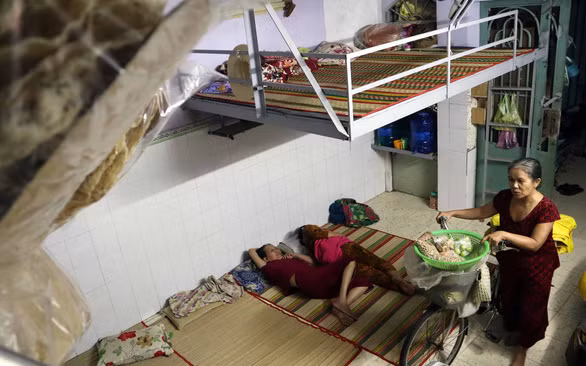 Bà Lệ lui cui đẩy xe đạp bán hàng rong về nhà “ngủ góp” lúc rạng sáng - Ảnh: LÊ VÂN