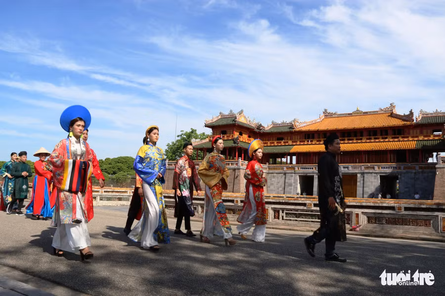 Đoàn rước áo dài đi ngang qua Ngọ Môn, tiến vào Triệu Tổ miếu ở Đại nội để dâng hương, hoa tưởng nhớ chúa Nguyễn Phúc Khoát - Ảnh: NHẬT LINH