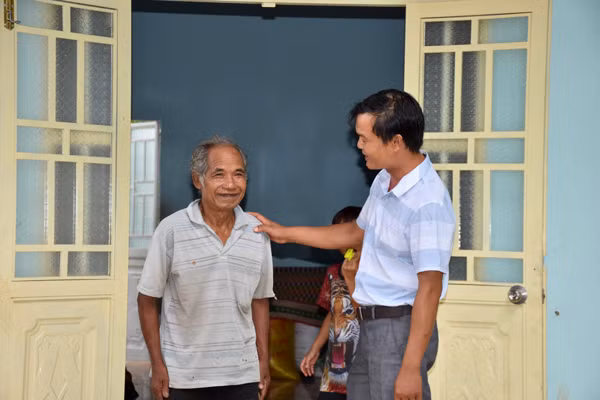 Bệnh binh Đinh Tok (bên trái ảnh-82 tuổi-làng Pốt, xã Song An, thị xã An Khê) phấn khởi trong ngôi nhà mới. Ảnh: Trần Dung 
