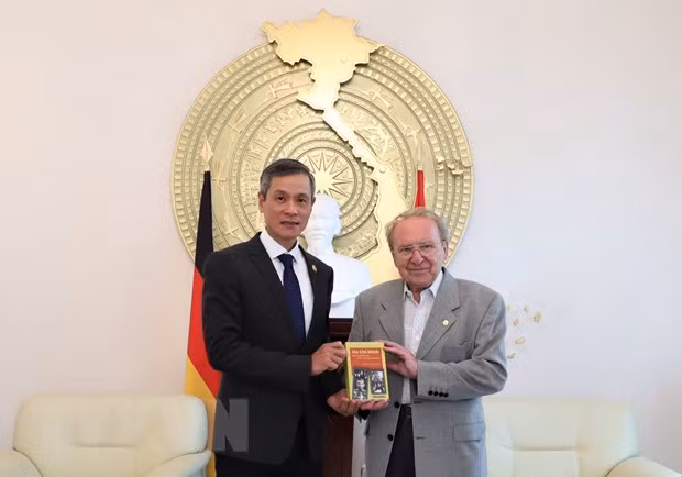 Nhà báo Hellmut Kapfenberger trao tặng Đại sứ Nguyễn Minh Vũ cuốn sách ''Tiểu sử chính trị Hồ Chí Minh'' mới xuất bản. (Ảnh: Thanh Bình/TTXVN)