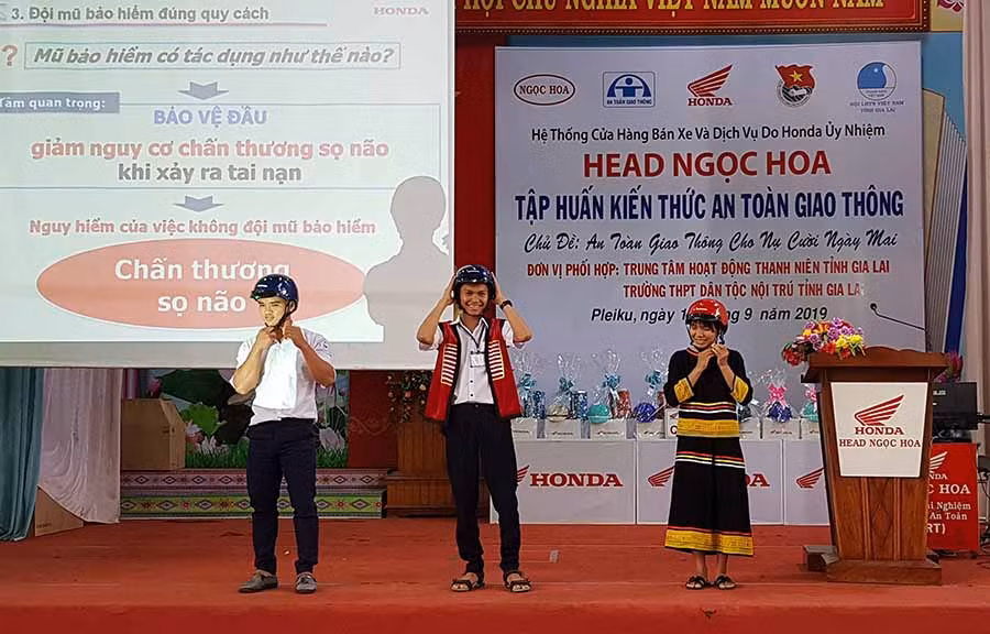  Các bạn học sinh thực hành đội mũ bảo hiểm đúng cách. Ảnh: H.Đ.T
