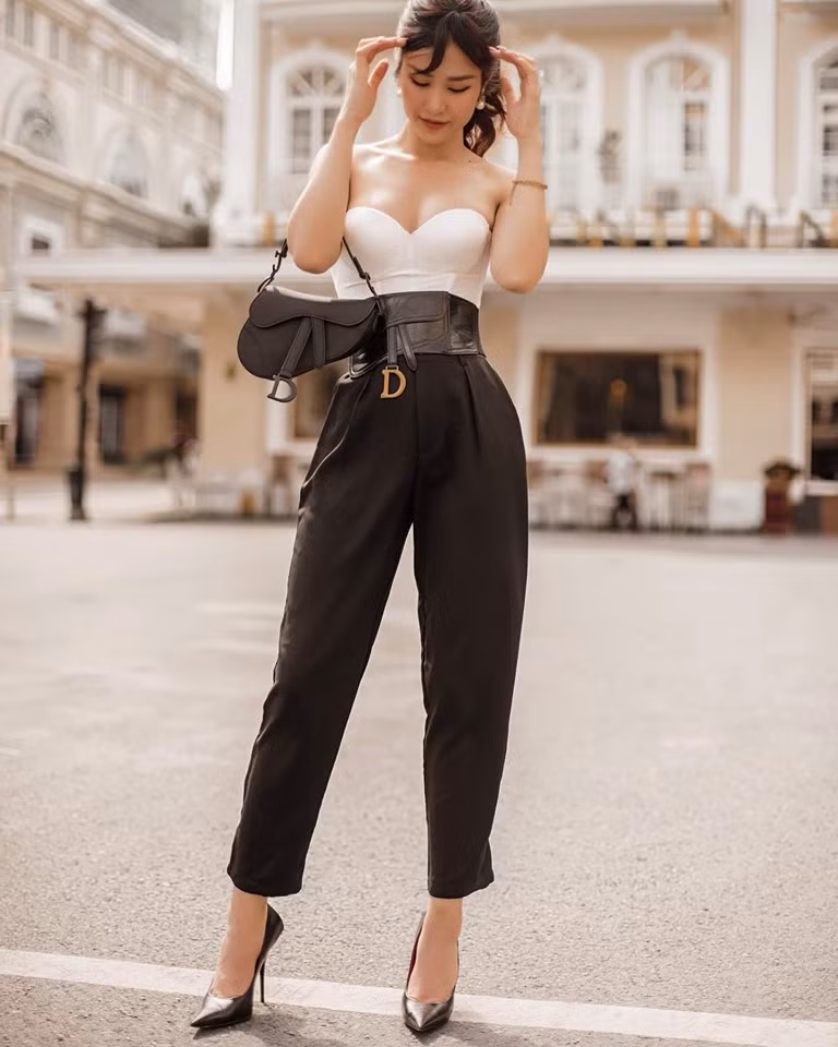  Dù không có chiều cao quá nổi trội nhưng Đông Nhi là sao nữ sở hữu vòng eo thon gọn, vóc dáng cân đối đáng ghen tị. Cũng nhờ vậy, cô có thể thỏa sức thử nghiệm nhiều phong cách khác nhau. Áo cúp ngực màu trắng kết hợp với quần đen, điểm nhấn là thắt lưng to bản giúp Đông Nhi khoe trọn vòng eo mảnh mai.