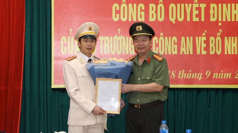 Đại tá Nguyễn Văn Trung - Ủy viên BTV Tỉnh ủy, Bí thư Đảng ủy, Giám đốc Công an tỉnh trao Quyết định và tặng hoa chúc mừng Thượng tá Lê Văn Tuấn