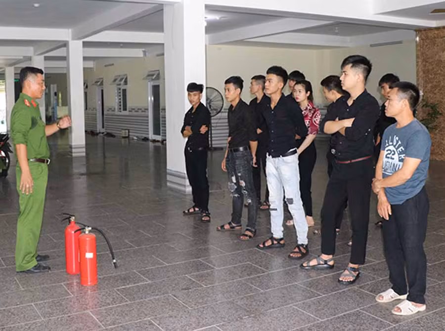 Cán bộ Đội Cảnh sát PCCC-CNCH khu vực An Khê hướng dẫn nhân viên một cơ sở kinh doanh cách sử dụng bình cứu hỏa. Ảnh: N.M