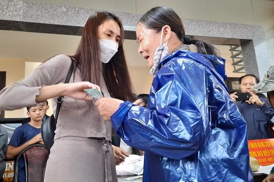 Người dân ở tỉnh Quảng Trị bị thiệt hại do mưa lũ nhận tiền hỗ trợ từ nữ ca sĩ Thủy Tiên vào cuối năm 2020. Ảnh: NV