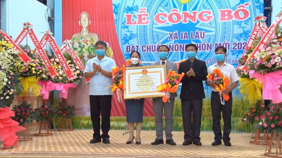 Lãnh đạo Văn phòng điều phối nông thôn mới tỉnh phối hợp với lãnh đạo Huyện ủy, UBND huyện Chư Prông trao bằng công nhận xã đạt chuẩn nông thôn mới năm 2020 cho lãnh đạo xã Ia Lâu. Ảnh: Hồng Thương