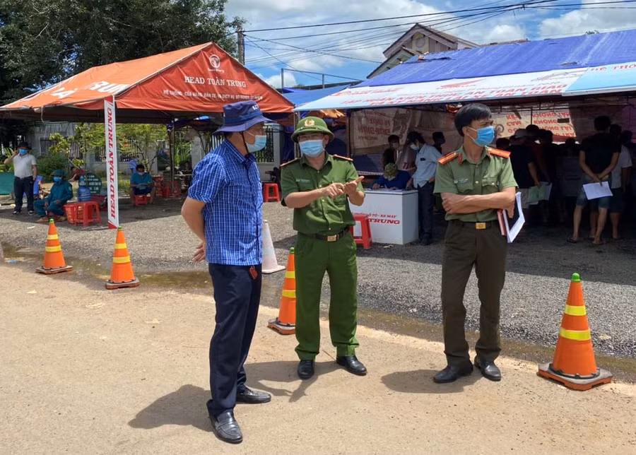 Ông Trần Văn Tư-Giám đốc Công ty TNHH một thành viên Toàn Trung (bìa trái) trao đổi với các lực lượng tại chốt kiểm soát phòng dịch Covid-19 khu vực cầu 110. Ảnh: Anh Huy