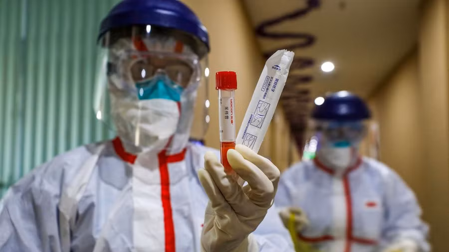 Nhân viên y tế tại Vũ Hán cầm mẫu xét nghiệm của bệnh nhân nghi mắc Covid-19. Ảnh: AFP