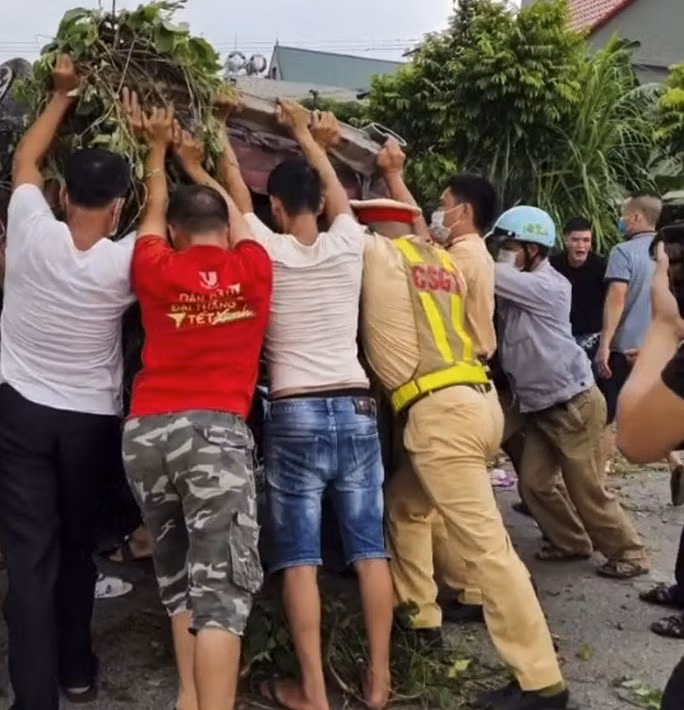 Người dân cùng lực lượng chức năng giải cứu những người mắc kẹt bên trong ra ngoài - Ảnh: Facbook