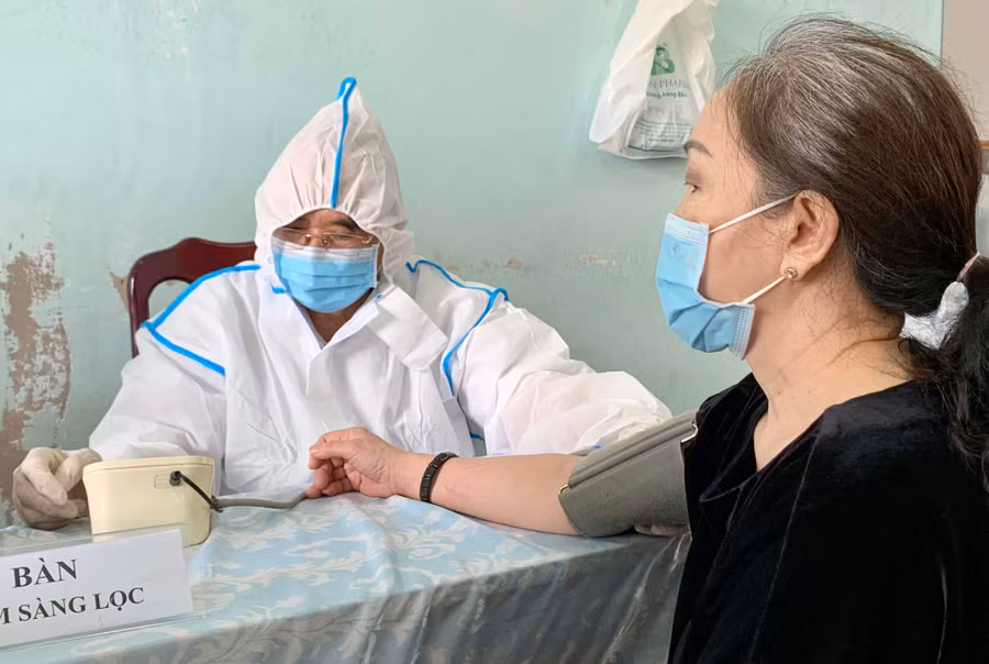 Ông Lưu Sỹ (tổ 1, phường Hội Thương) tham gia khám sàng lọc cho người dân trước khi tiêm chủng. Ảnh: Như Ý