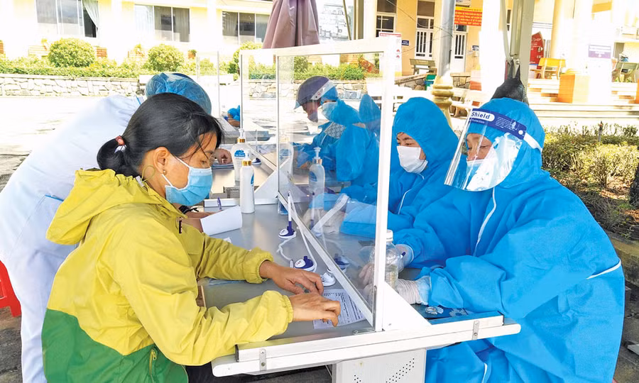 Người dân thực hiện khai báo y tế, đo thân nhiệt trước khi vào khám-chữa bệnh tại Bệnh viện Đa khoa tỉnh. Ảnh: Ngọc Thu