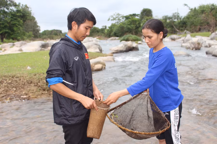  Vợ chồng anh Giang Pơ Đam bắt cá đá ở suối Tơ Tung. Ảnh: Phan Lài