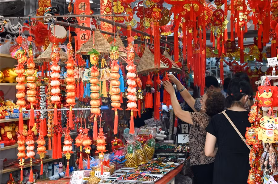  Một người phụ nữ ngắm đồ trang trí Tết tại Singapore. Ảnh: AFP