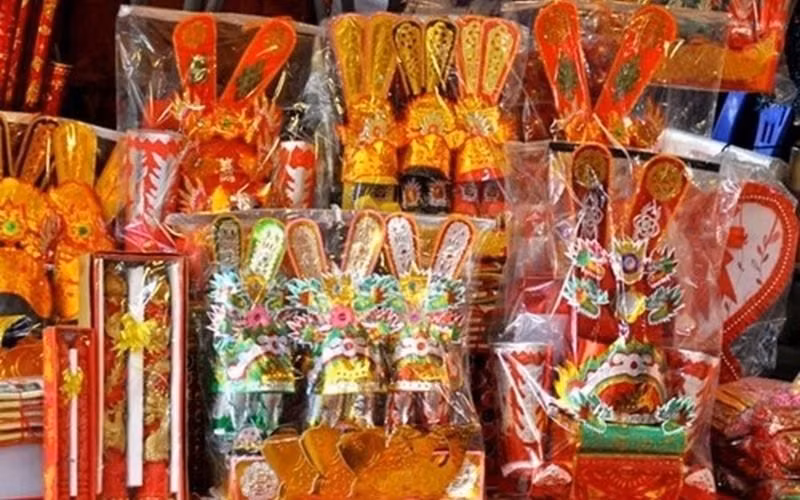 Chuẩn bị ba bộ mũ áo, hia hài cúng ông Công ông Táo cùng vàng nén. Ảnh: TL