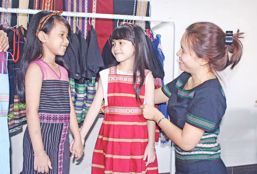 Để trẻ em yêu mến văn hóa truyền thống, chị RCom H'Sonh (bìa phải) đã thiết kế những bộ váy cách tân, phù hợp với lứa tuổi các em. Ảnh: Phan Lài Để trẻ em yêu mến văn hóa truyền thống, chị RCom H'Sonh (bìa phải) đã thiết kế những bộ váy cách tân, phù hợp với lứa tuổi các em. Ảnh: Phan Lài