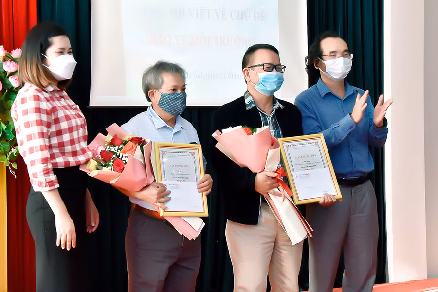 Bà Nguyễn Thị Kim Liên-Phó Giám đốc Văn phòng Tổng đại lý Prudential Gia Lai (bìa trái) và ông Khuất Đình Viện-Phó Tổng biên tập Báo Gia Lai (bìa phải) trao giải nhì cho các tác giả tại buổi lễ. Ảnh: Đức Thụy 