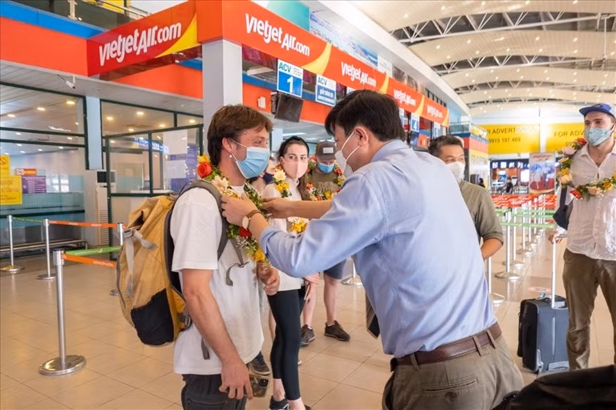 Đại diện Sở Du lịch tỉnh Quảng Bình tặng hoa cho khách du lịch quốc tế. Ảnh: LPL