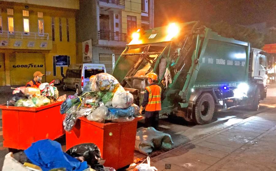 Xe chở rác làm việc hết công suất để thu gom rác hoàn thành trước 6 giờ sáng ngày mùng 1 Tết. Ảnh. Đinh Yến