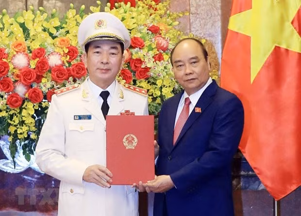 Chủ tịch nước Nguyễn Xuân Phúc trao Quyết định thăng cấp bậc hàm từ Trung tướng lên Thượng tướng đối với Thứ trưởng Bộ Công an Trần Quốc Tỏ. (Ảnh: Thống Nhất/TTXVN)