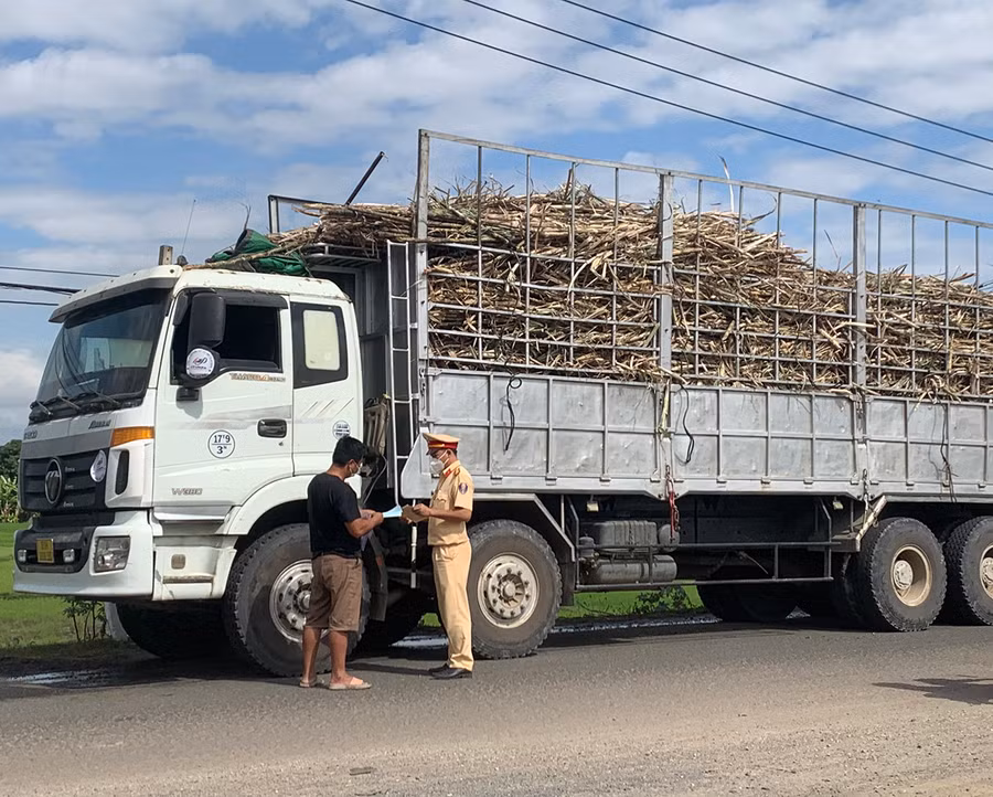 Lực lượng Cảnh sát Giao thông (Công an thị xã Ayun Pa) kiểm tra, nhắc nhở các tài xế không chở quá khổ, quá tải khi vận chuyển nông sản (Vũ Chi).jpg