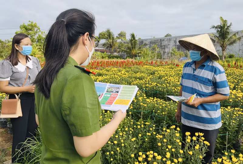 Công an xã Long Đức phát tờ rơi tuyên truyền phòng, chống tội phạm đến người dân.