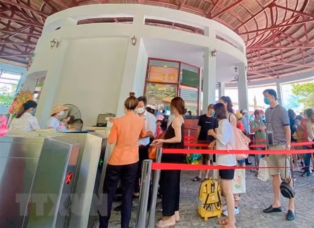 Du khách phải thực hiện khai báo y tế, đeo khẩu trang trước khi vào khu du lịch ở Đà Nẵng. Ảnh: TTXVN phát