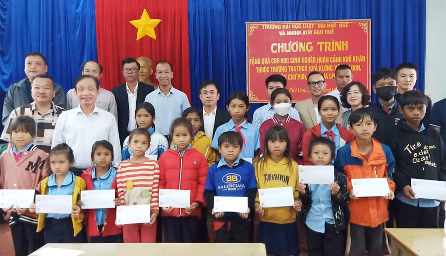 Các em học sinh nhận quà của Trường Đại học Luật-Đại học Huế. Ảnh: Huyền Ly
