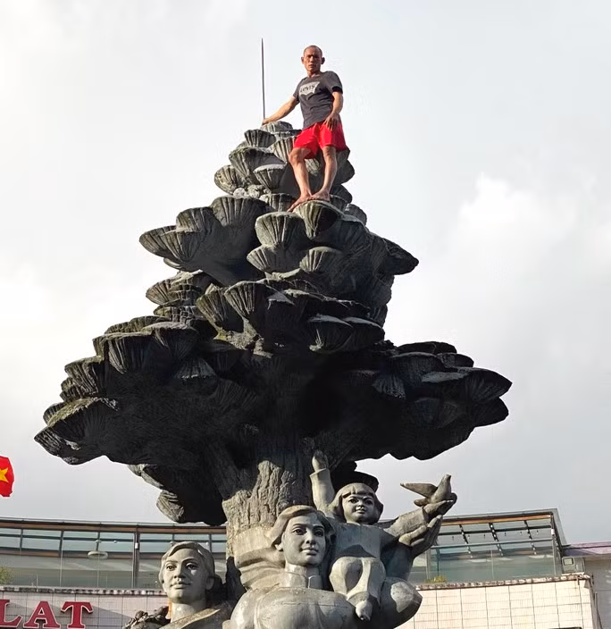 Nam thanh niên leo lên nóc tượng đài trước chợ Đà Lạt.