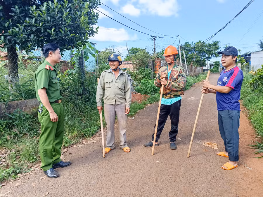  Cán bộ Công an xã Ia Pết trao đổi công việc với các thành viên Tổ tự quản an ninh trật tự thôn 10. Ảnh: R'Ô HOK