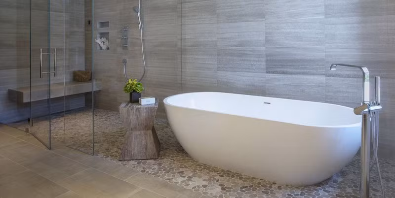 Thiết kế phòng tắm tối giản với chiếc bồn trắng làm nổi bật các vật liệu tự nhiên như tường gỗ, đôn gỗ và bình hoa nhỏ. Thiết kế phòng tắm tối giản với chiếc bồn trắng làm nổi bật các vật liệu tự nhiên như tường gỗ, đôn gỗ và bình hoa nhỏ.