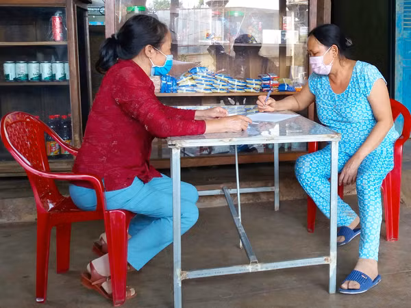 Cán bộ thú y phường Trà Bá (TP. Pleiku) tuyên truyền, vận động người dân nuôi chó, mèo ký cam kết tuân thủ các quy định của pháp luật. Ảnh: N.N