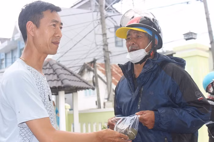 Ông Long vui mừng nhận dòn bánh tét của những nhà hảo tâm giữa màu dịch Covid-19.