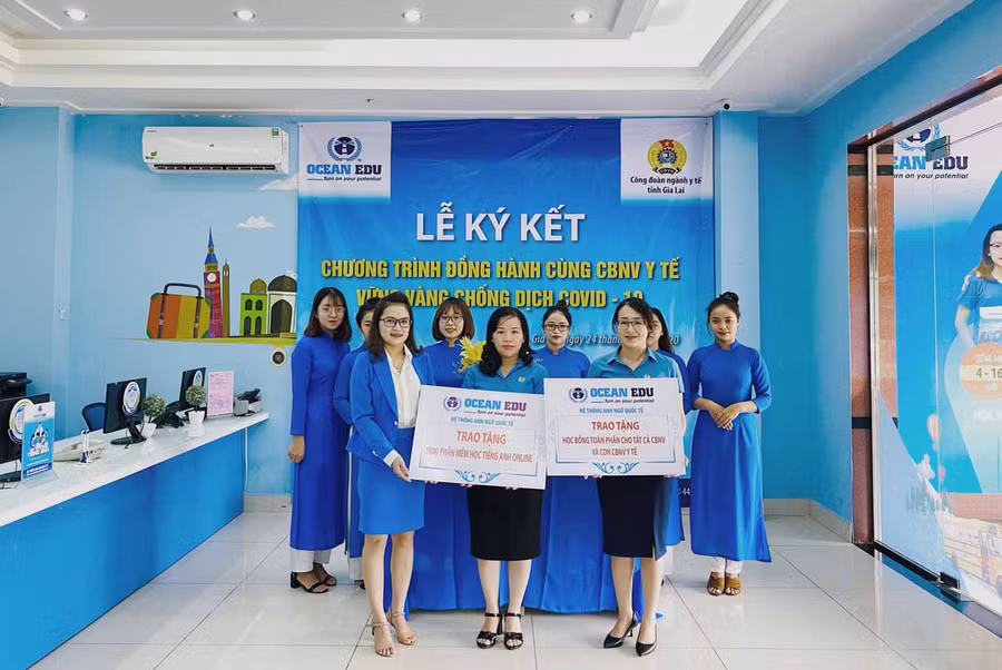 Bà Nguyễn Thị Ánh Xuân (giữa)- Chủ tịch Công đoàn ngành Y tế Gia Lai nhận bảng tượng trưng đại diện Trung tâm Anh ngữ Ocean Edu trao. Ảnh: Như Nguyện