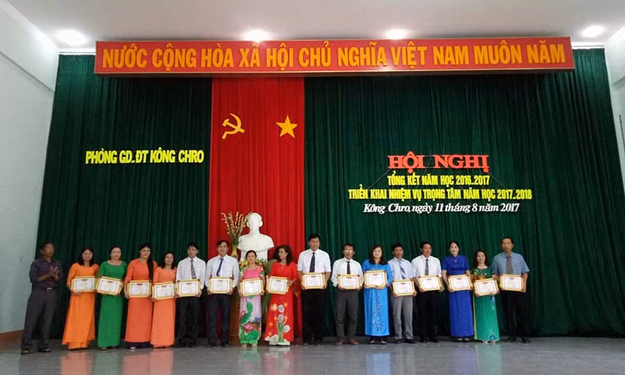  Đồng chí Đinh Kinh-Phó Chủ tịch UBND huyện tặng giấy khen cho 16 tập thể đạt danh hiệu tập thể lao động tiên tiến năm học 2016-2017. Ảnh: Phương Liên