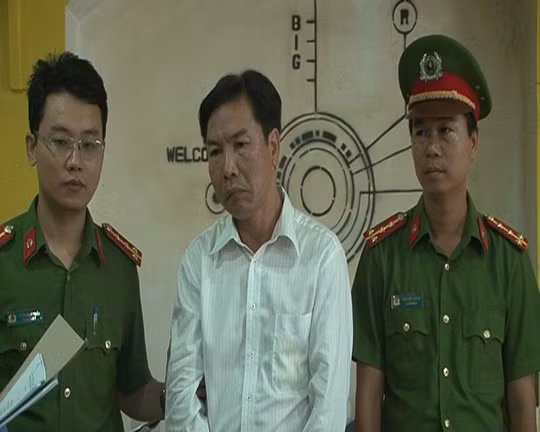 Bị can Lê Hữu Lam (đứng giữa) bị cơ quan công an bắt tạm giam.