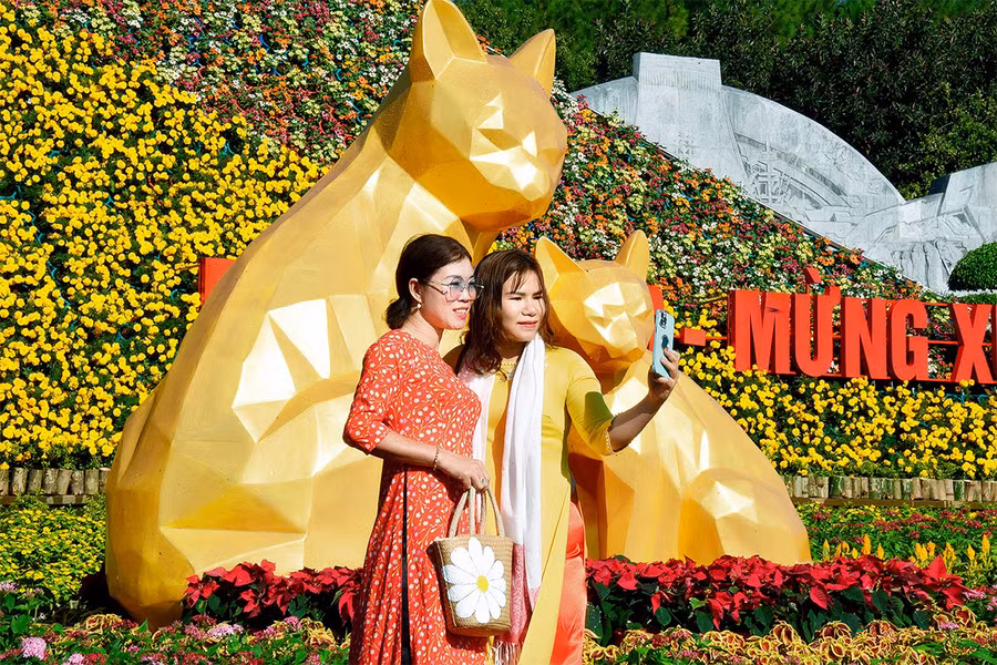 Khách tham quan thích thú lưu lại những khoảnh khắc đẹp bên gia đình tại đường hoa Quảng trường Đại Đoàn Kết.