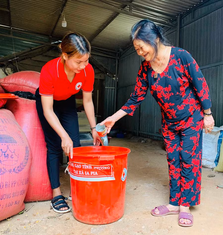  Bà Nguyễn Thị Hiên (bìa phải) bớt một phần gạo của gia đình để ủng hộ hũ gạo tình thương. Ảnh: Hồng Thương