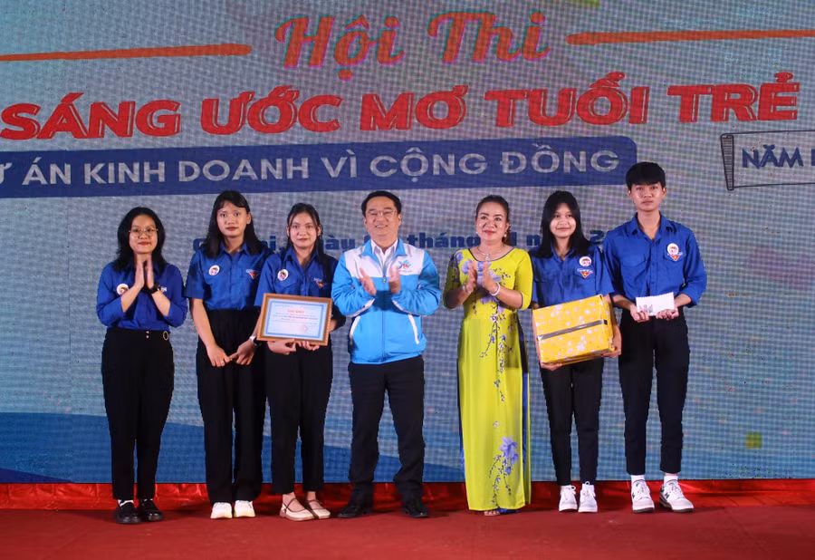 Ban tổ chức trao giải nhất cho đội thi Trường THPT Nguyễn Bỉnh Khiêm. Ảnh: Phan Lài