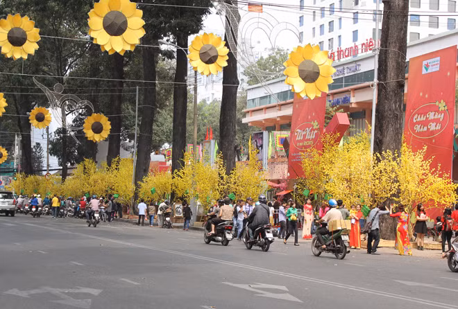 Những ngày này, nhiều người Sài Gòn xúng xính áo dài, khăn đóng đến khu vực đường Lê Duẩn, Phạm Ngọc Thạch (quận 1) chụp ảnh với những cành đào, cành mai được dựng lên dọc hai tuyến đường.