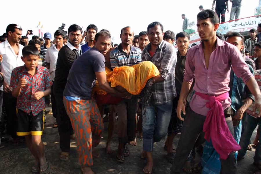 Người dân Bangladesh đang khiêng thi thể một nạn nhân trong vụ chìm phà tại quận Manikganj, cách thủ đô Dhaka về phía Tây khoảng 30 km - Ảnh: AFP