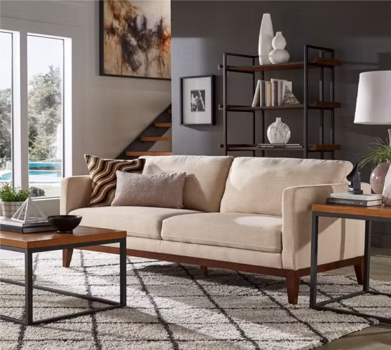Thêm chỗ ngồi, chỗ tiếp khách đầy phong cách với ghế sofa bọc vải màu trung tính, khung ghế làm bằng gỗ tự nhiên để lộ phần chân ra bên ngoài mang thêm nét cuốn hút cho phòng khách.