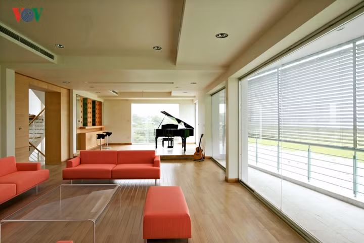  Phòng khách hiện đại, là một không gian lớn kết nối với không gian hồ qua các ô cửa lớn. Màu sắc tương phản mạnh.